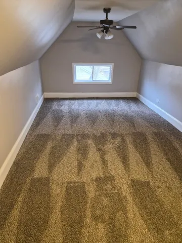 an empty room with a ceiling fan and window