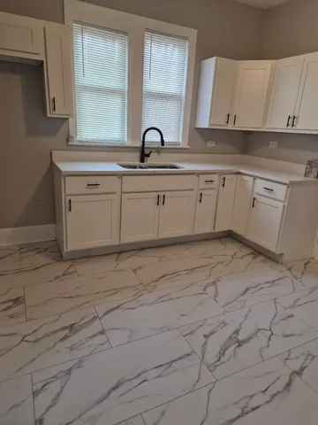 a kitchen with a sink cabinets and window