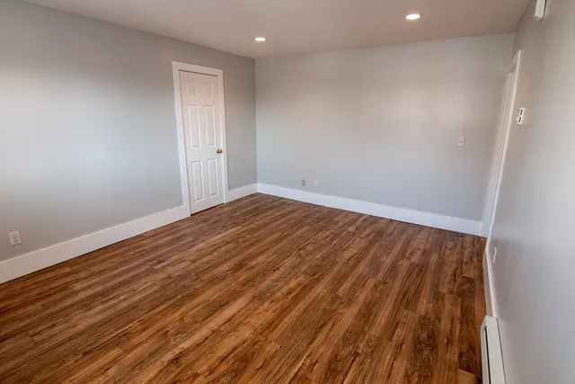 a view of room with wooden floor and white walls