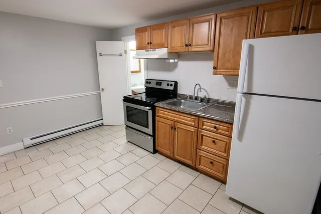 a kitchen with stainless steel appliances granite countertop a refrigerator sink stove and cabinets