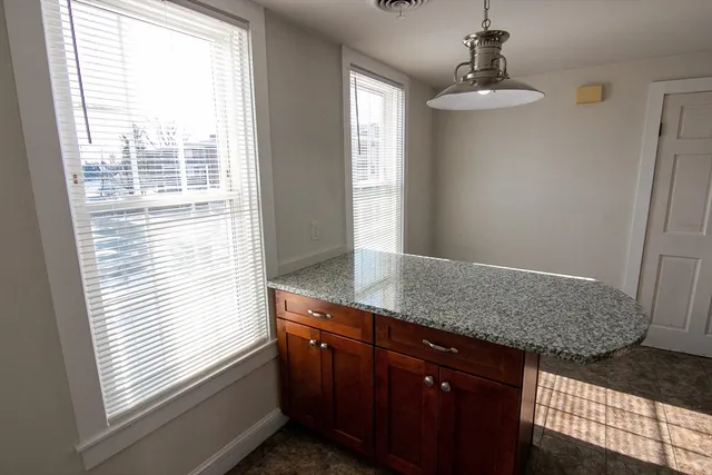 a bathroom with a granite countertop sink and window
