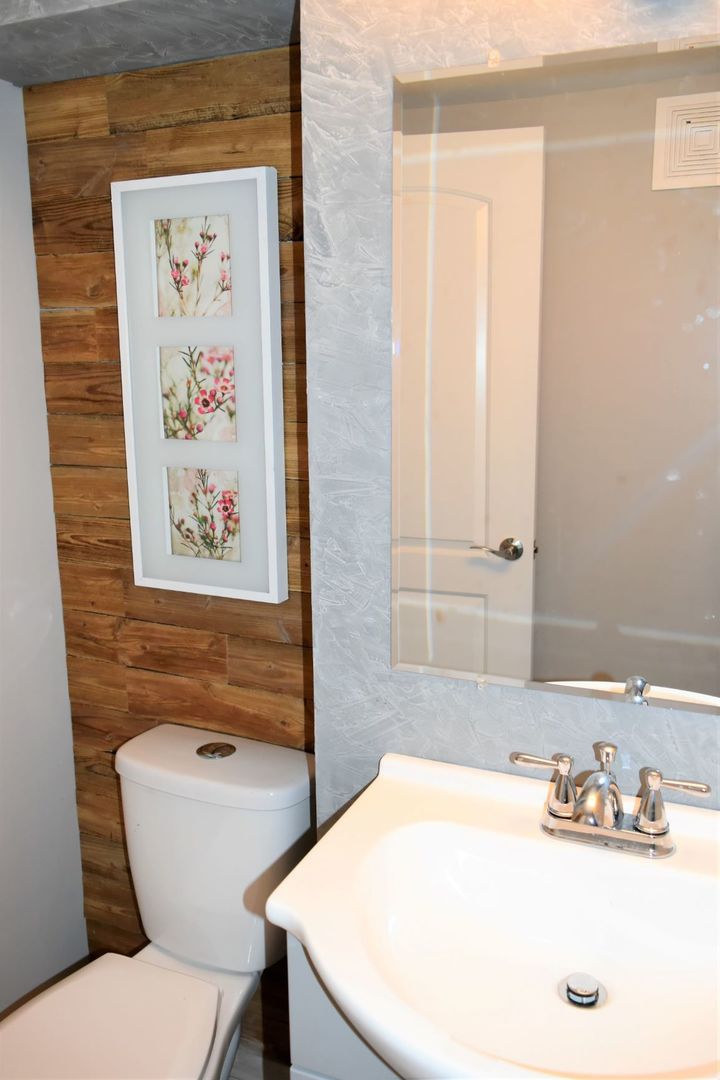 9405 South Laflin Street Chicago, IL 60620 - Photo 17 of 24 a bathroom with a sink a mirror and a toilet