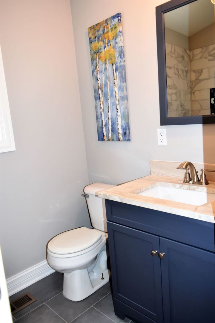 9405 South Laflin Street Chicago, IL 60620 - Photo 21 of 24 a bathroom with a toilet a sink and mirror