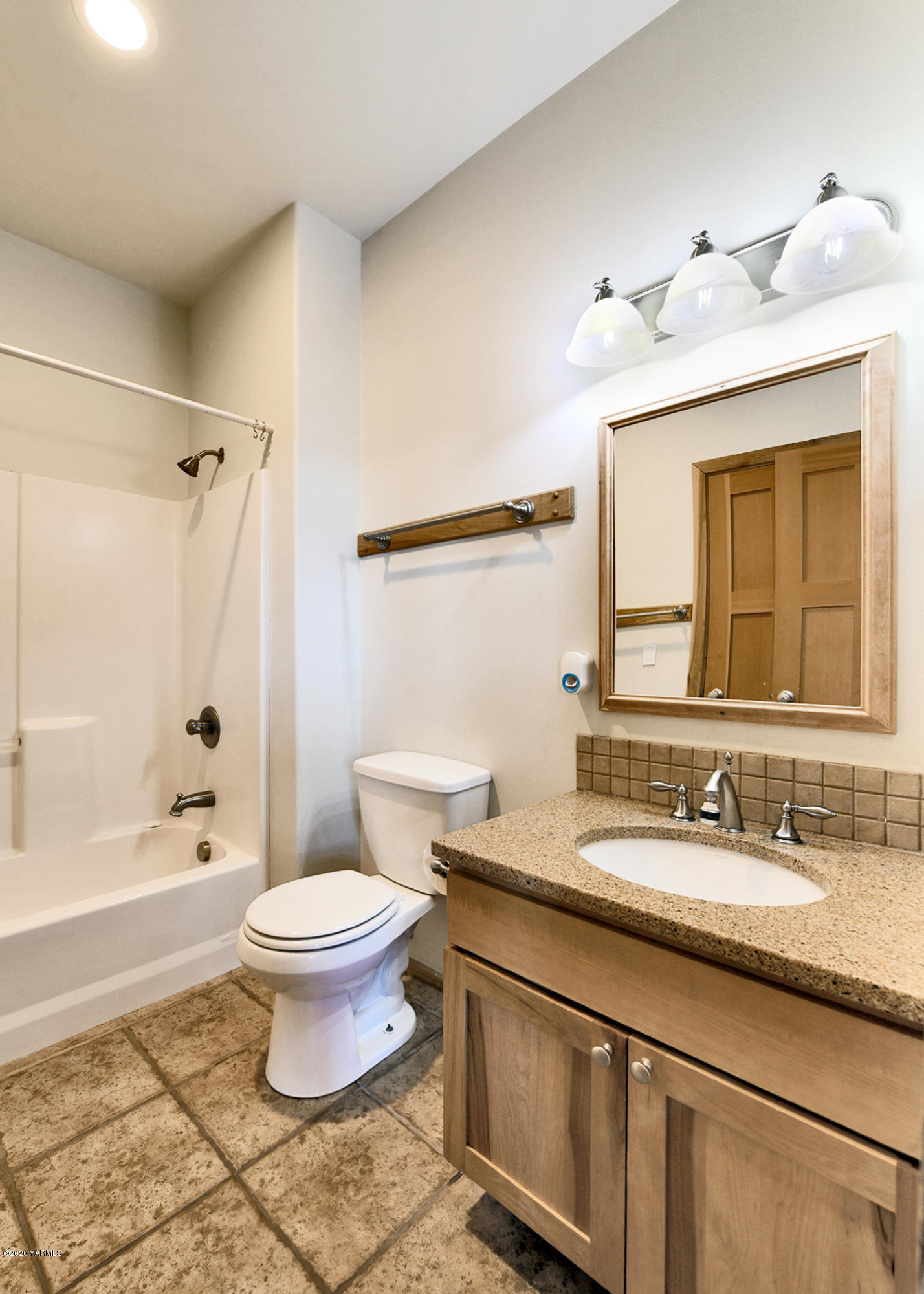 451 Black Hawk Road Yakima, WA 98908 - Photo 12 of 27 a bathroom with a granite countertop sink toilet a mirror a bathtub and shower