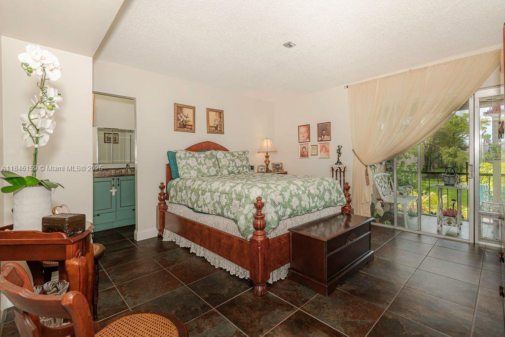8401 Southwest 107th Avenue, Unit 214E Miami, FL 33173 - Photo 16 of 28 a bedroom with a bed and a couch next to a window