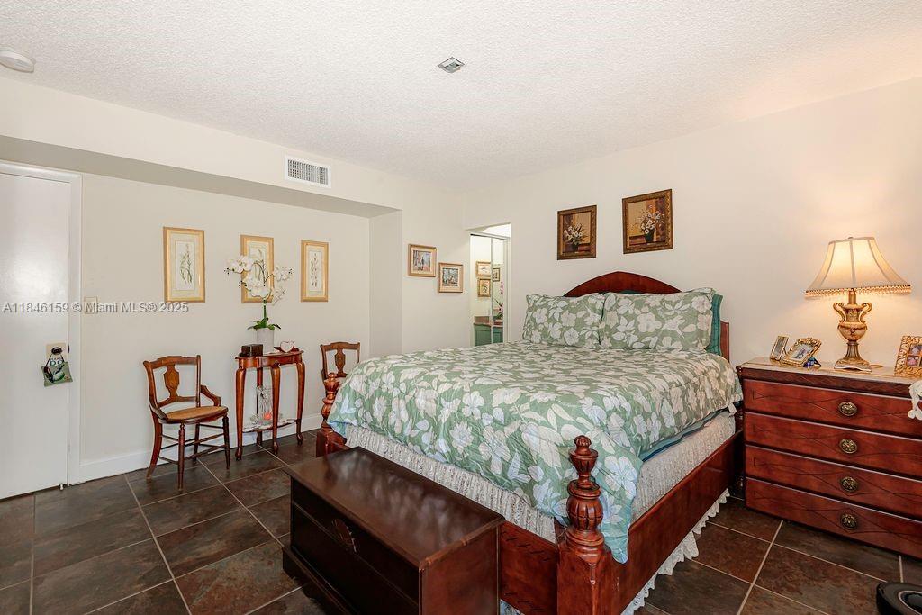 8401 Southwest 107th Avenue, Unit 214E Miami, FL 33173 - Photo 17 of 28 a bedroom with a bed and a dresser in it