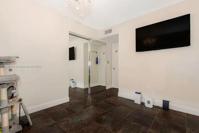 a living room with a flat screen tv and a view of bathroom