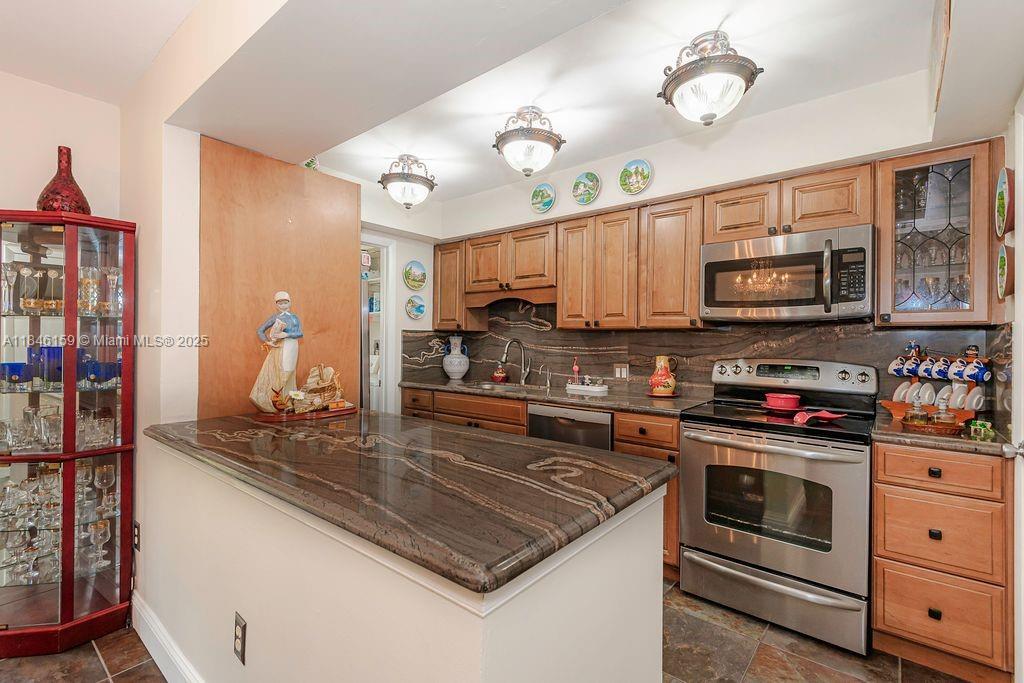8401 Southwest 107th Avenue, Unit 214E Miami, FL 33173 - Photo 6 of 28 a kitchen with stainless steel appliances granite countertop a stove microwave and cabinets