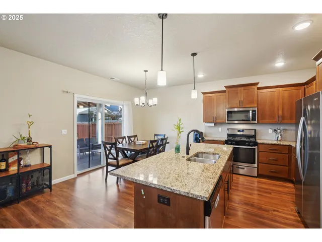 a kitchen with stainless steel appliances granite countertop a sink refrigerator and cabinets