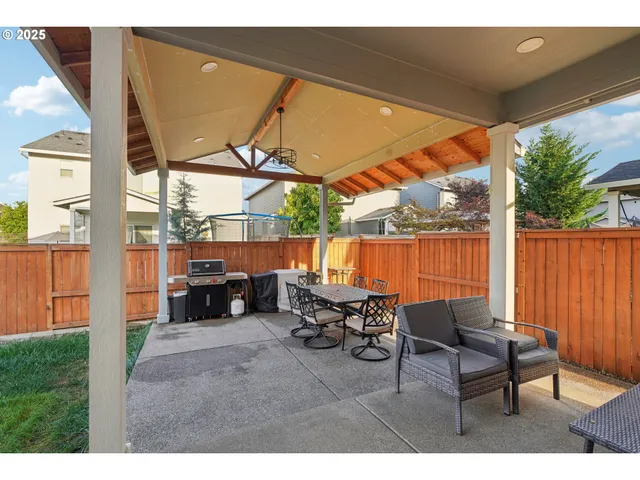 a view of a chairs and table in the back yard of the house