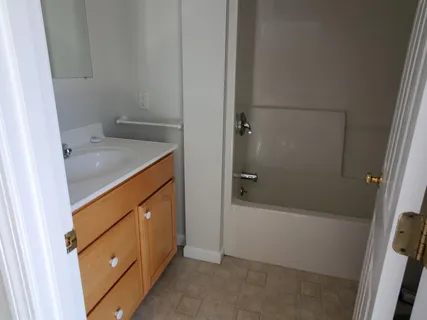 a bathroom with a granite countertop sink a toilet and shower