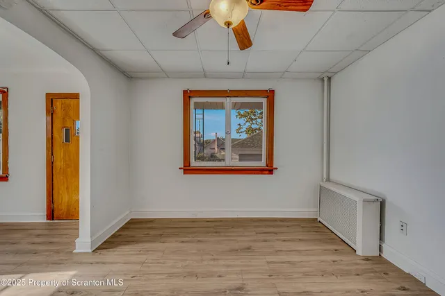 a view of an empty room with wooden floor