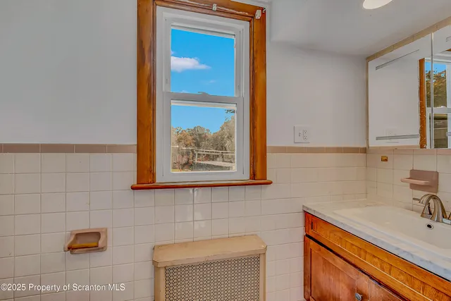 a bathroom with a sink mirror and tub