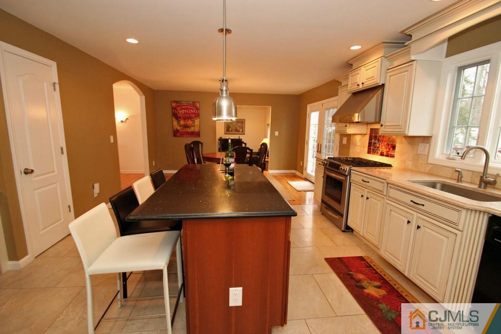 32 Timber Road Edison, NJ 08820 - Photo 6 of 25 a kitchen with kitchen island granite countertop a sink a counter top space appliances and cabinets