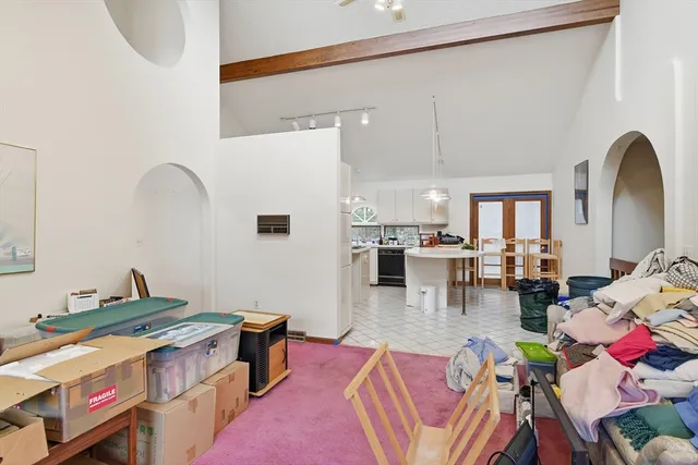 a living room with furniture and a dining table with kitchen view