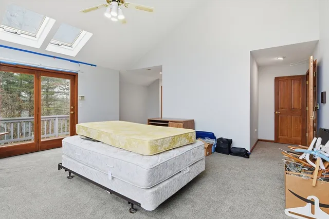 a spacious bedroom with a bed and a chandelier