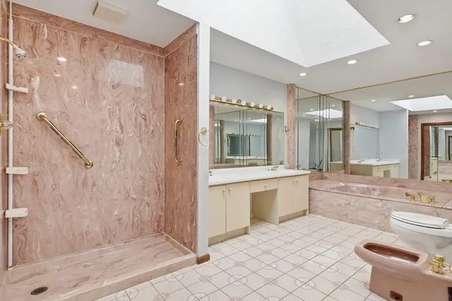 a large bathroom with a granite countertop sink a toilet a mirror and shower