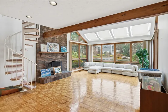 a living room with fireplace furniture and a large window