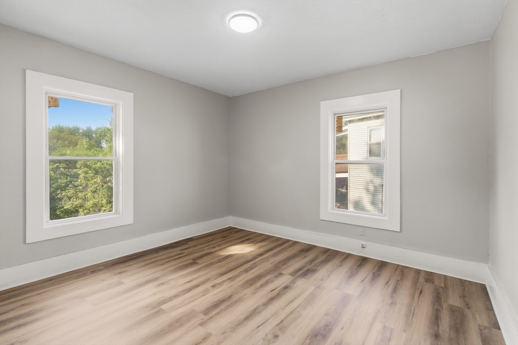 834 Worthington Street, Unit 2 Springfield, MA 01105 - Photo 9 of 20 an empty room with wooden floor and windows
