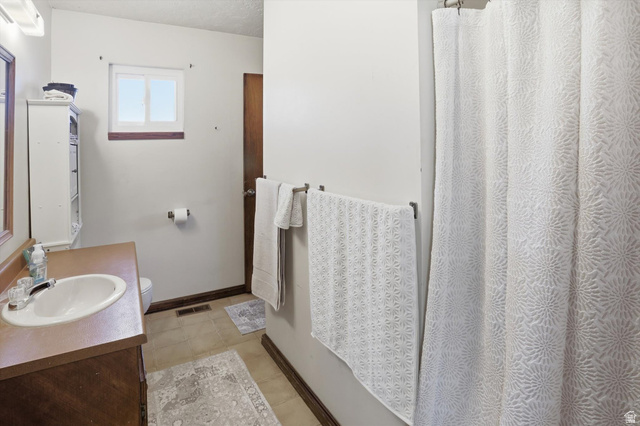 380 North 200 West Logan, UT 84321 - Photo 17 of 29 Bathroom featuring vanity, a shower with shower curtain, and light tile patterned floors