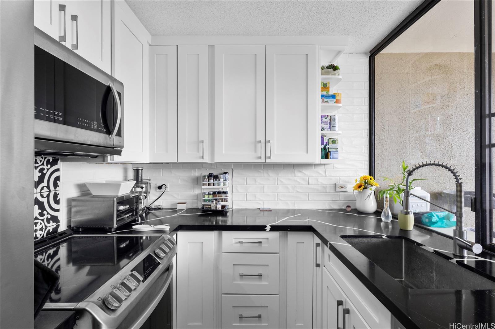 965 Prospect Street, Unit 404 Honolulu, HI 96822 - Photo 11 of 24 a kitchen with stainless steel appliances a sink a stove cabinets and a kitchen island