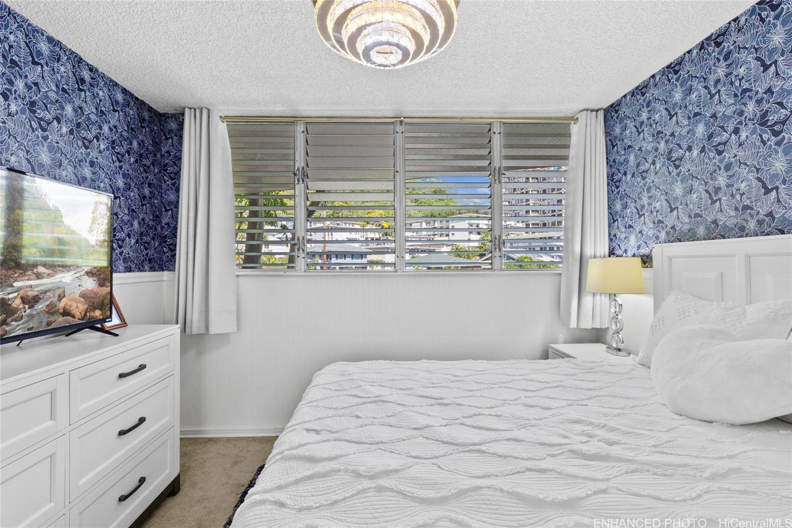 965 Prospect Street, Unit 404 Honolulu, HI 96822 - Photo 5 of 24 a bedroom with a bed and a flat tv screen on dresser