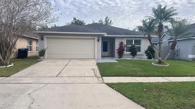 a front view of a house with a yard and potted plants