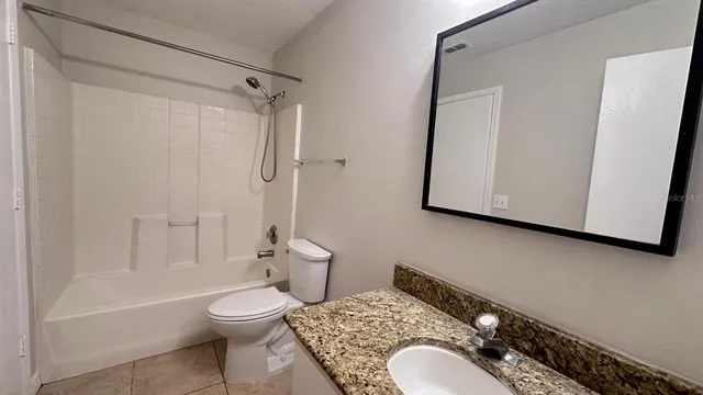 a bathroom with a granite countertop toilet sink and shower