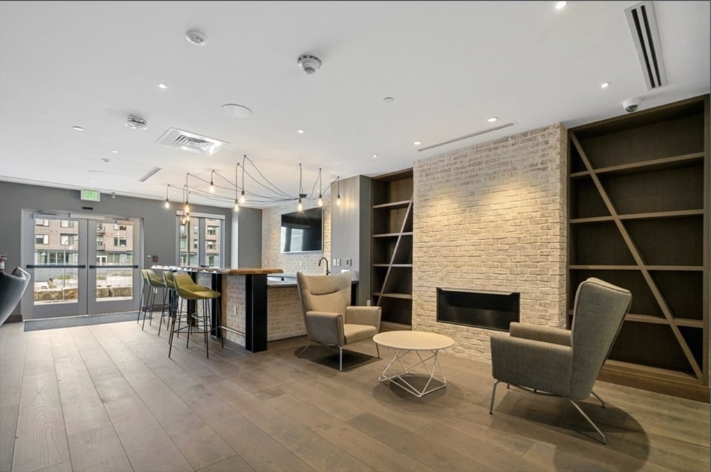 45 Lewis Street, Unit 312 Boston, MA 02128 - Photo 14 of 17 a living room with furniture a fireplace and a table