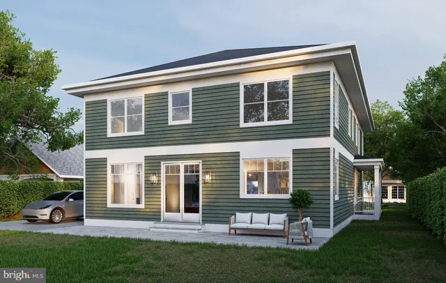 a front view of a house with a yard and green space