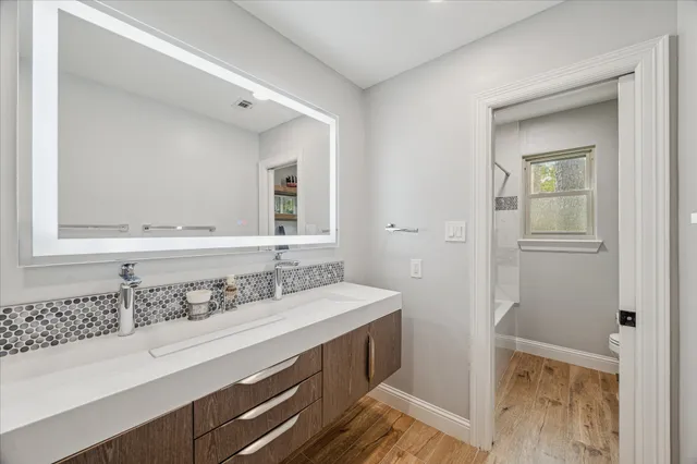 a room with wooden floor pool table and windows