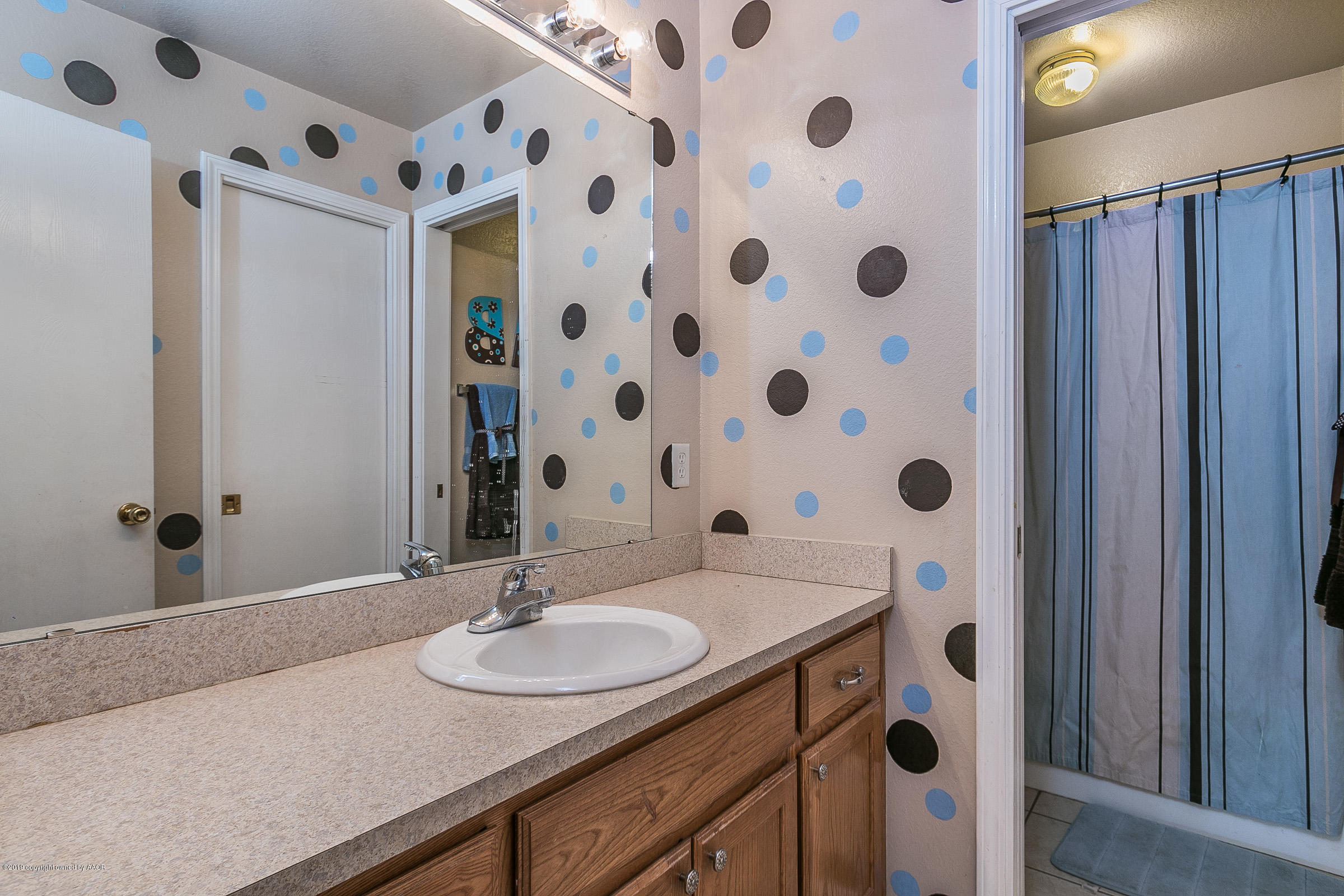 1168 Rushmore Drive Amarillo, TX 79110 - Photo 20 of 25 a bathroom with a sink and a mirror