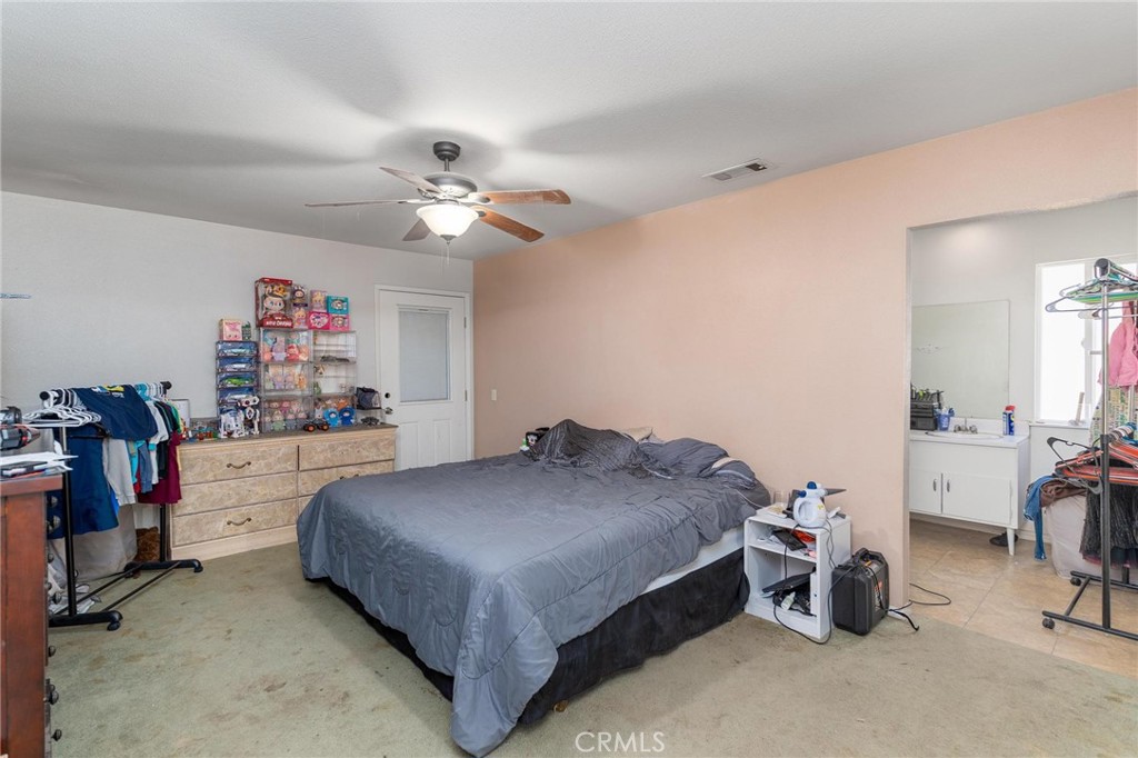 81901 Victoria Street Indio, CA 92201 - Photo 19 of 29 a bedroom with a bed and a chandelier