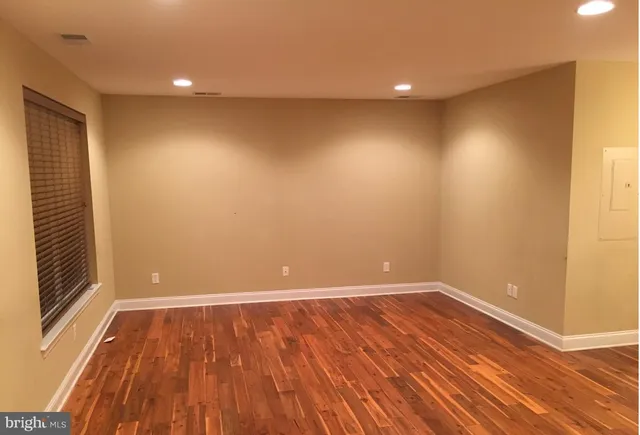 a view of room with wooden floor and entrance