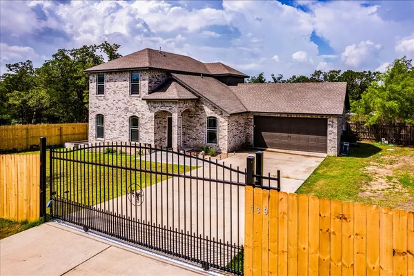 a view of a brick house with wooden fence
