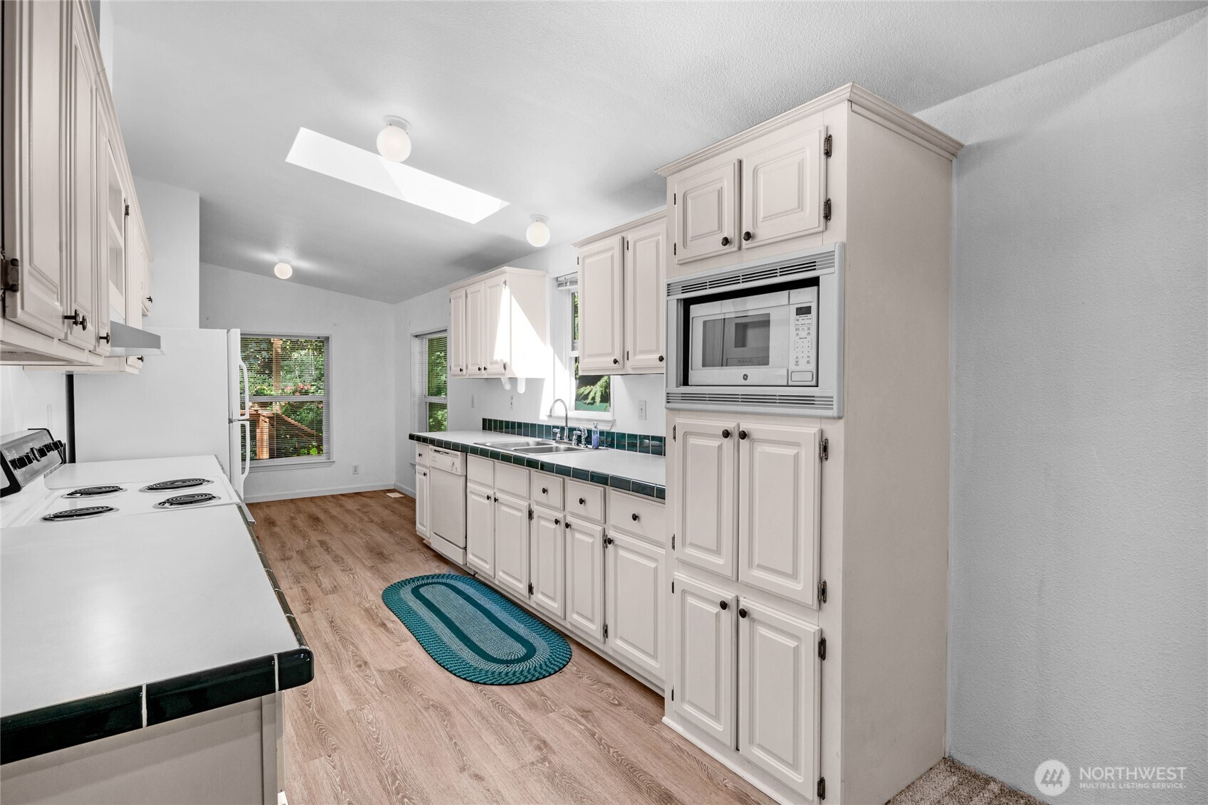 22222 49th Avenue Southeast Bothell, WA 98021 - Photo 7 of 37 a kitchen with granite countertop a sink stove and cabinets