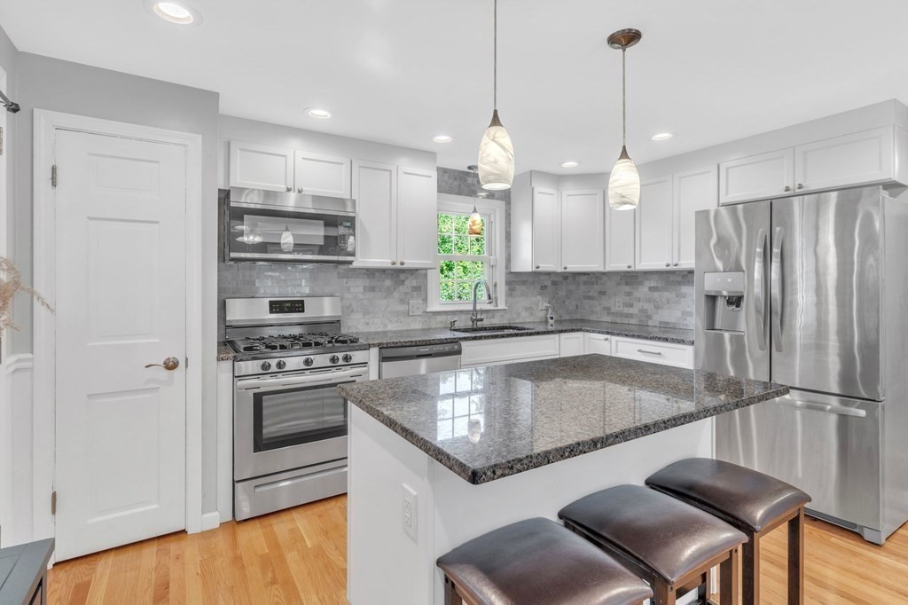 83 Moss Road Springfield, MA 01119 - Photo 7 of 42 a kitchen with stainless steel appliances granite countertop a sink a stove a refrigerator and island