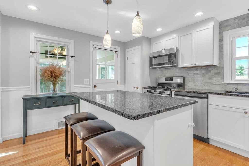 83 Moss Road Springfield, MA 01119 - Photo 8 of 42 a kitchen with stainless steel appliances granite countertop a sink a stove a microwave a center island and cabinets