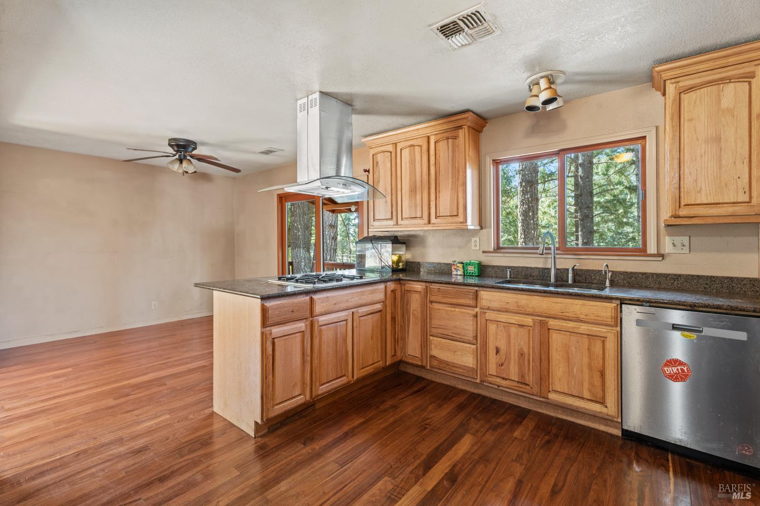 3781 Ridgewood Road Willits, CA 95490 - Photo 5 of 18 a kitchen with stainless steel appliances granite countertop wooden floors sink and window