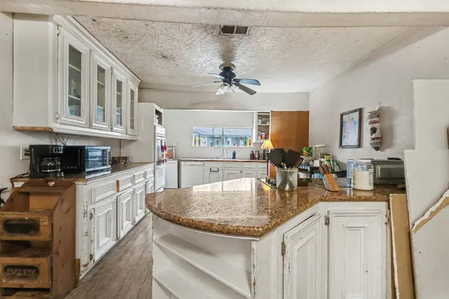 a kitchen with stainless steel appliances granite countertop a sink a stove and cabinets
