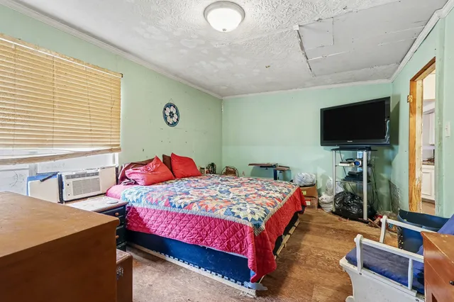 a bedroom with a bed and a flat screen tv