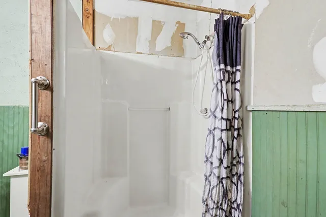 a bathroom with a shower curtain and a window