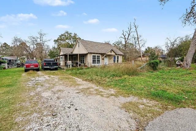 a front view of a house with a garden and tree