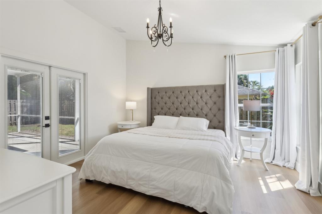 6254 Lucerne Street Jupiter, FL 33458 - Photo 13 of 30 a bedroom with a large bed and a chandelier
