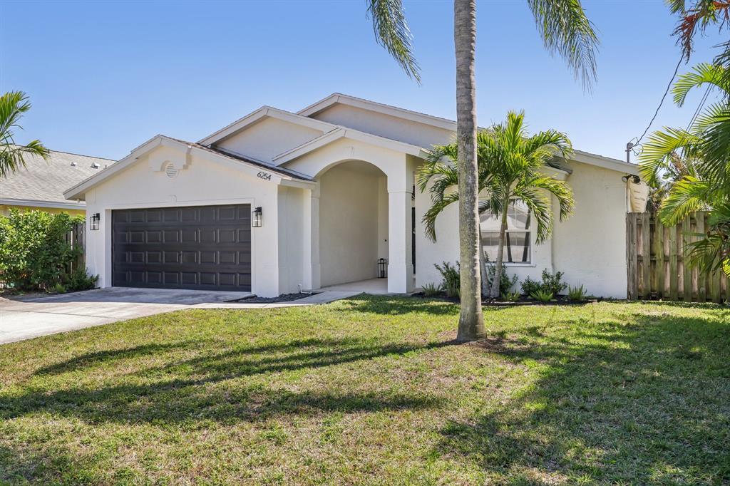 6254 Lucerne Street Jupiter, FL 33458 - Photo 2 of 30 a front view of a house with a garden