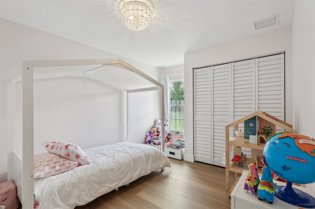 6254 Lucerne Street Jupiter, FL 33458 - Photo 21 of 30 a bedroom with a bed and wooden floor