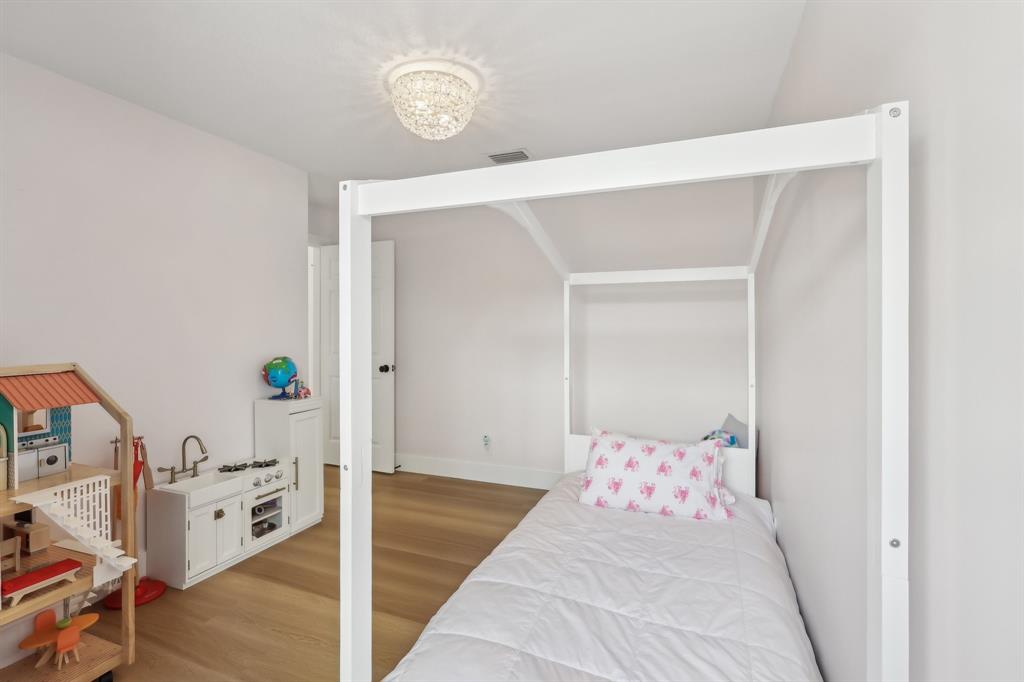 6254 Lucerne Street Jupiter, FL 33458 - Photo 22 of 30 a bedroom with a bed and a chandelier