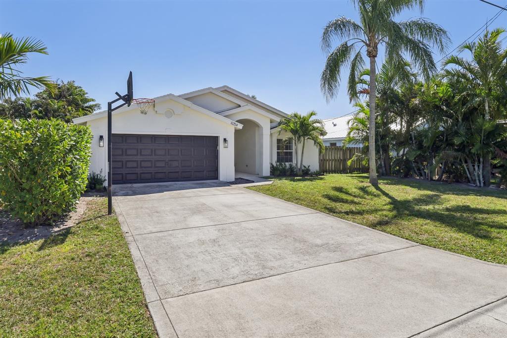 6254 Lucerne Street Jupiter, FL 33458 - Photo 30 of 30 a front view of a house with a yard and garage