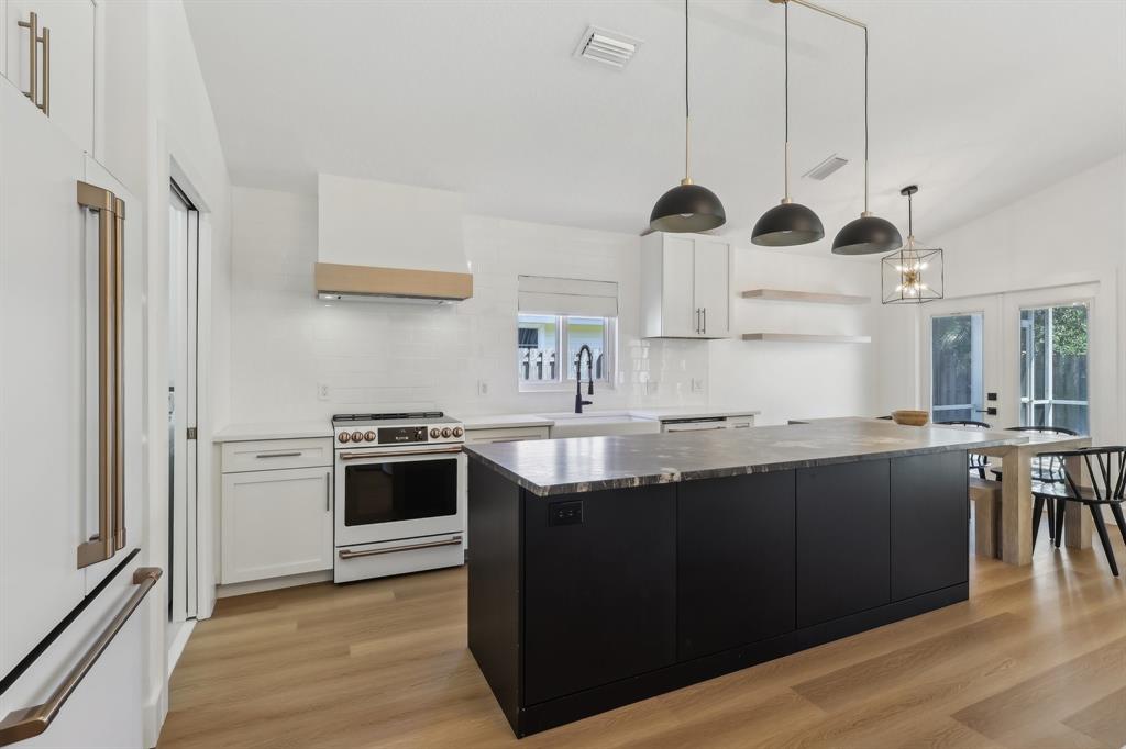 6254 Lucerne Street Jupiter, FL 33458 - Photo 4 of 30 a kitchen with stainless steel appliances granite countertop a sink a stove and refrigerator