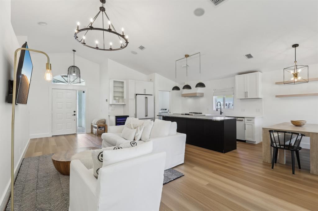 6254 Lucerne Street Jupiter, FL 33458 - Photo 7 of 30 a kitchen with a sink dishwasher a dining table and chairs with wooden floor